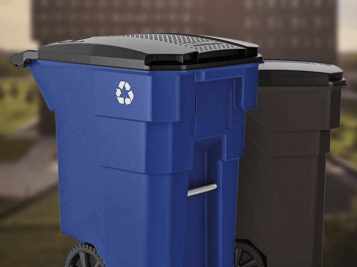 A blue curbside recycling cart with the recycling symbol, beside a dark gray trash cart